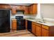 The kitchen features wooden cabinets, granite countertops, and black appliances at 612 Stadler Pointe, Mcdonough, GA 30253