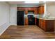 Well-lit kitchen featuring wood cabinets, granite countertops, and modern black appliances at 612 Stadler Pointe, Mcdonough, GA 30253