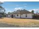 Back exterior featuring white siding, black trim, and a well-maintained lawn at 1243 Old Villa Rica Rd, Dallas, GA 30157