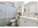 Cozy bathroom with vanity, toilet, and shower featuring patterned shower curtain at 1243 Old Villa Rica Rd, Dallas, GA 30157