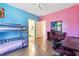 Bedroom with bunkbeds, desk, pink and blue walls and wood floor at 1243 Old Villa Rica Rd, Dallas, GA 30157