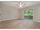 Neutral bedroom with wood-look flooring, ceiling fan, and sliding glass doors to a balcony at 2940 Leah Ln, Douglasville, GA 30135