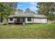 Exterior view of back of home with white siding, black trim, a small deck, and a large, grassy backyard at 4902 Cedar Se Ct, Conyers, GA 30094