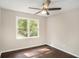 Bedroom featuring hardwood floors, neutral paint, a ceiling fan, and a large window overlooking the backyard at 4902 Cedar Se Ct, Conyers, GA 30094