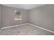 Bedroom featuring neutral gray paint, window, and new gray carpet at 8740 Parliament Pl, Jonesboro, GA 30238