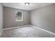 Bedroom featuring neutral gray paint, window, and new gray carpet at 8740 Parliament Pl, Jonesboro, GA 30238