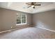 A spacious bedroom features a trey ceiling with fan, carpet, and a large window at 8740 Parliament Pl, Jonesboro, GA 30238