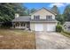 Two-story home with a traditional facade, featuring a two-car garage and a well-maintained lawn at 8740 Parliament Pl, Jonesboro, GA 30238