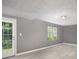 Spacious room featuring light gray walls, light flooring, and a door leading to the backyard at 8740 Parliament Pl, Jonesboro, GA 30238