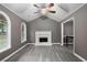 Cozy living room with vaulted ceilings, a white brick fireplace, and neutral gray paint with gray floors at 8740 Parliament Pl, Jonesboro, GA 30238