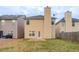 Backyard with a small concrete patio, green grass and yellow siding and a fenced perimeter at 11143 Aliyah Dr, Hampton, GA 30228