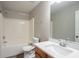 Neutral bathroom with a shower-tub combo, white sink with wood-look cabinet and large mirror at 11143 Aliyah Dr, Hampton, GA 30228