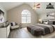 Staged bedroom with sitting area, vaulted ceiling, large window, and gray wood floors at 11143 Aliyah Dr, Hampton, GA 30228