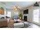A staged living room boasts a fireplace, ceiling fan, neutral colors, and a door to the back yard at 11143 Aliyah Dr, Hampton, GA 30228