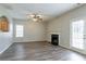 A living room offers luxury vinyl plank flooring, a fireplace, ceiling fan, and access to the backyard at 11143 Aliyah Dr, Hampton, GA 30228