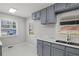 Bright kitchen featuring marble tile flooring, blue cabinets, a modern sink and marble countertops at 1808 Brewer Sw Blvd, Atlanta, GA 30310