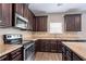 Well-equipped kitchen with stainless steel appliances, granite countertops, and dark wood cabinetry at 4950 Summersun Dr, Morrow, GA 30260