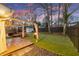 A backyard featuring an outdoor dining area with a fire pit, shed, and artificial turf creates the perfect ambiance at 541 Benmac Se Rd, Smyrna, GA 30080