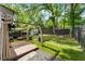 Backyard with covered outdoor seating, lush grass, privacy fence and a shed at 541 Benmac Se Rd, Smyrna, GA 30080