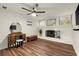 Living room with a fan and fireplace with painted brick at 541 Benmac Se Rd, Smyrna, GA 30080