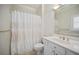Well-lit bathroom featuring a shower with decorative curtain, classic vanity, and patterned wallpaper at 8540 Hope Mews Ct, Atlanta, GA 30350