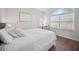 Light filled bedroom with large arched window, white linens and hardwood floors at 8540 Hope Mews Ct, Atlanta, GA 30350