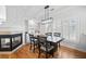 Cozy dining area with a modern chandelier, fireplace, and natural light from large windows at 8540 Hope Mews Ct, Atlanta, GA 30350
