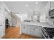Open-concept kitchen featuring white cabinets, a breakfast bar, and stainless steel appliances at 8540 Hope Mews Ct, Atlanta, GA 30350