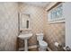 Stylish powder room featuring a pedestal sink, patterned wallpaper, and a window at 8540 Hope Mews Ct, Atlanta, GA 30350