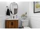 Half bathroom featuring a wood vanity, oval mirror, shiplap accent wall, and modern fixtures for a stylish design at 2316 Defoors Ferry Nw Rd, Atlanta, GA 30318