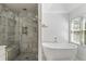 Elegant bathroom with a marble walk-in shower and a modern soaking tub near a bright window at 2316 Defoors Ferry Nw Rd, Atlanta, GA 30318