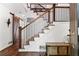 Foyer features hardwood floors, a staircase with black metal railings, and a wooden bench, creating an inviting entrance at 2316 Defoors Ferry Nw Rd, Atlanta, GA 30318