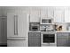 Modern kitchen featuring stainless steel appliances, white cabinets, and gray countertops, offering a stylish cooking space at 2316 Defoors Ferry Nw Rd, Atlanta, GA 30318