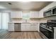 Modern kitchen showcasing stainless steel appliances, white cabinetry, and durable flooring at 3534 S Portsmouth Cir, Lithonia, GA 30038