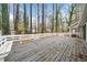 Backyard deck featuring white fencing and bench seating surrounded by a lush, wooded landscape at 806 Longfellow Ct, Stone Mountain, GA 30088