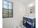 Charming bathroom featuring a navy blue vanity with white countertop and striking patterned tile flooring at 806 Longfellow Ct, Stone Mountain, GA 30088