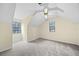 Angled bedroom featuring cozy carpet, two windows, and light-colored walls with a ceiling fan at 806 Longfellow Ct, Stone Mountain, GA 30088