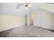 Sloped bedroom featuring neutral walls, plush carpet, and a ceiling fan with door leading to the hallway at 806 Longfellow Ct, Stone Mountain, GA 30088