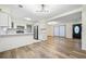 Open-concept living room featuring modern lighting, wood floors, and access to the kitchen and front door at 806 Longfellow Ct, Stone Mountain, GA 30088
