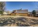 View of the backyard of a yellow home with a lawn and a stone patio at 105 Bentley Place Way, Covington, GA 30016
