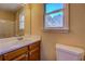 Bathroom with vanity, large mirror, toilet, and a window view of trees at 105 Bentley Place Way, Covington, GA 30016