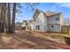Backyard view of two story home with wooden garden beds and tree coverage at 1116 Oak Hollow Ln, Hampton, GA 30228
