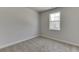 Bedroom with neutral carpet, grey walls and a bright window at 1238 Ainsworth Aly # 38, Sugar Hill, GA 30518