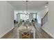 Bright dining room open to living room has hardwood floors, and modern chandelier at 1238 Ainsworth Aly # 38, Sugar Hill, GA 30518