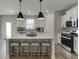Bright kitchen featuring a large island with seating, sleek stainless appliances and modern pendant lights at 1238 Ainsworth Aly # 38, Sugar Hill, GA 30518