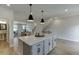 Modern open kitchen featuring an island with seating and a view of the dining and living areas at 1238 Ainsworth Aly # 38, Sugar Hill, GA 30518
