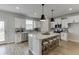 Bright kitchen with stainless steel appliances, granite countertops, and pendant lighting over island at 1238 Ainsworth Aly # 38, Sugar Hill, GA 30518