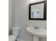 Modern powder room with pedestal sink, mirror and toilet at 1238 Ainsworth Aly # 38, Sugar Hill, GA 30518