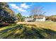Wide backyard with lush grass, mature trees, and a view of the home's rear facade at 1505 Ozora Rd, Loganville, GA 30052