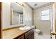 Traditional bathroom features a single sink, framed mirror and adjacent toilet near a bright window at 1505 Ozora Rd, Loganville, GA 30052